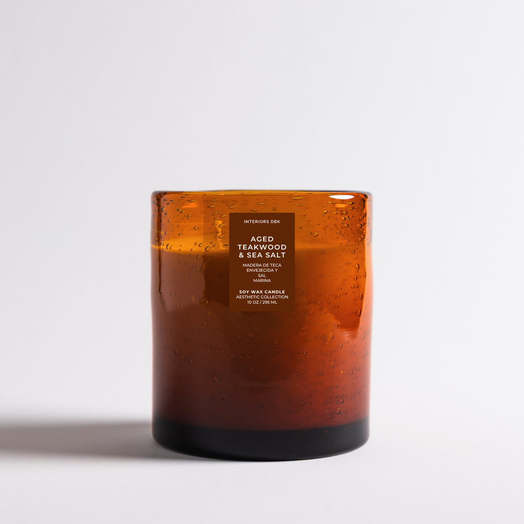 Aged Teakwood and Salt soy candle in hand blown amber glass jar, moody woodsy luxury home fragrance by Interiors DBK.