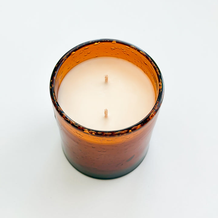 Luxury woodsy soy candle in reusable amber glass with masculine fragrance notes.