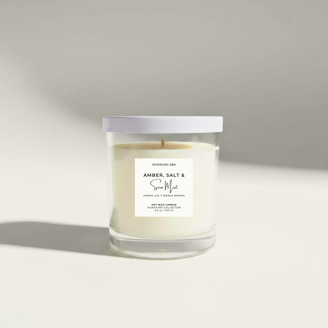 Amber, Salt & Sea Mist 6.5 oz soy candle by Interiors DBK in clear glass jar with minimalist label and white metal lid.