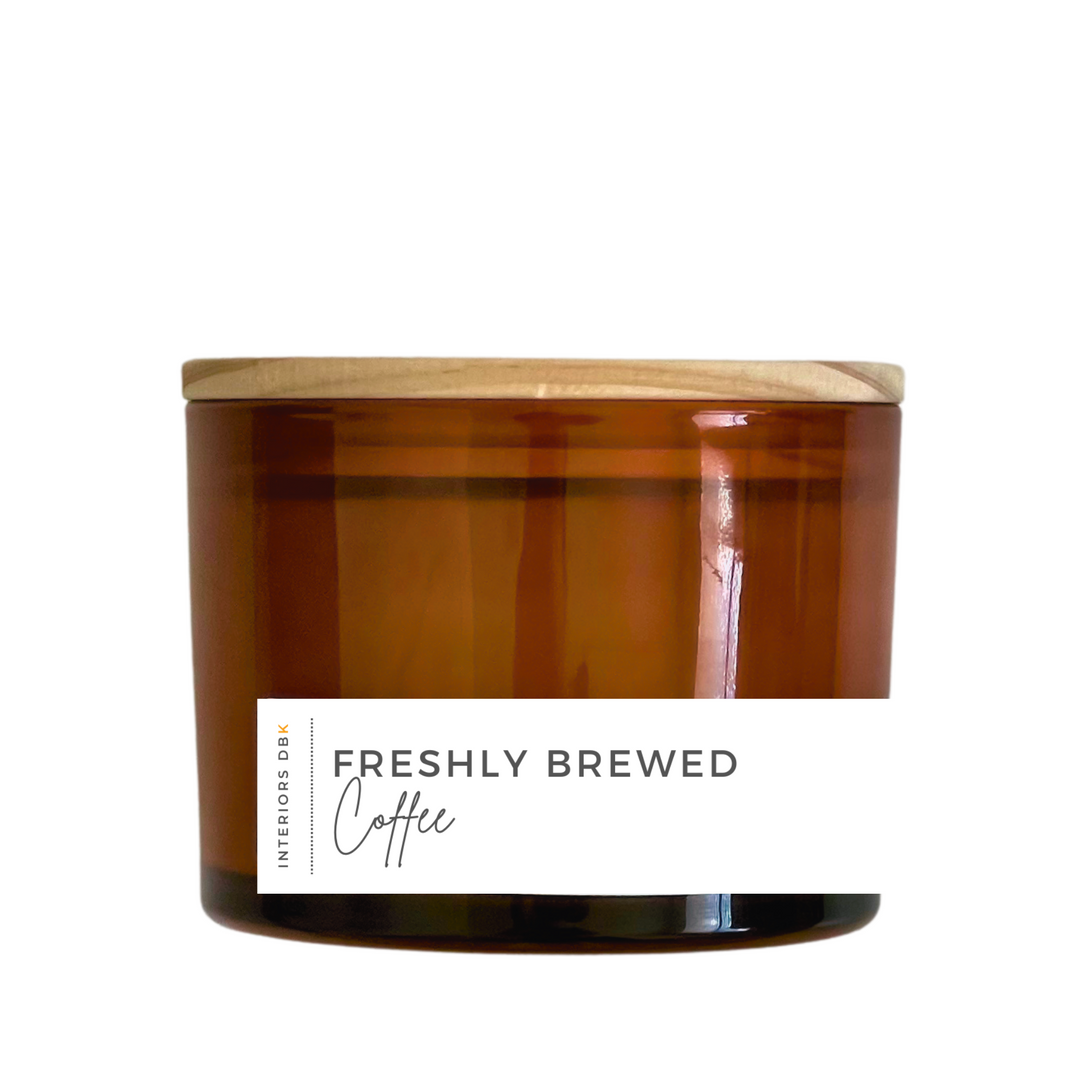 A large Freshly Brewed Coffee soy candle in an amber glass vessel with a natural wood lid, featuring a 12 oz volume and a sophisticated, sustainable design.