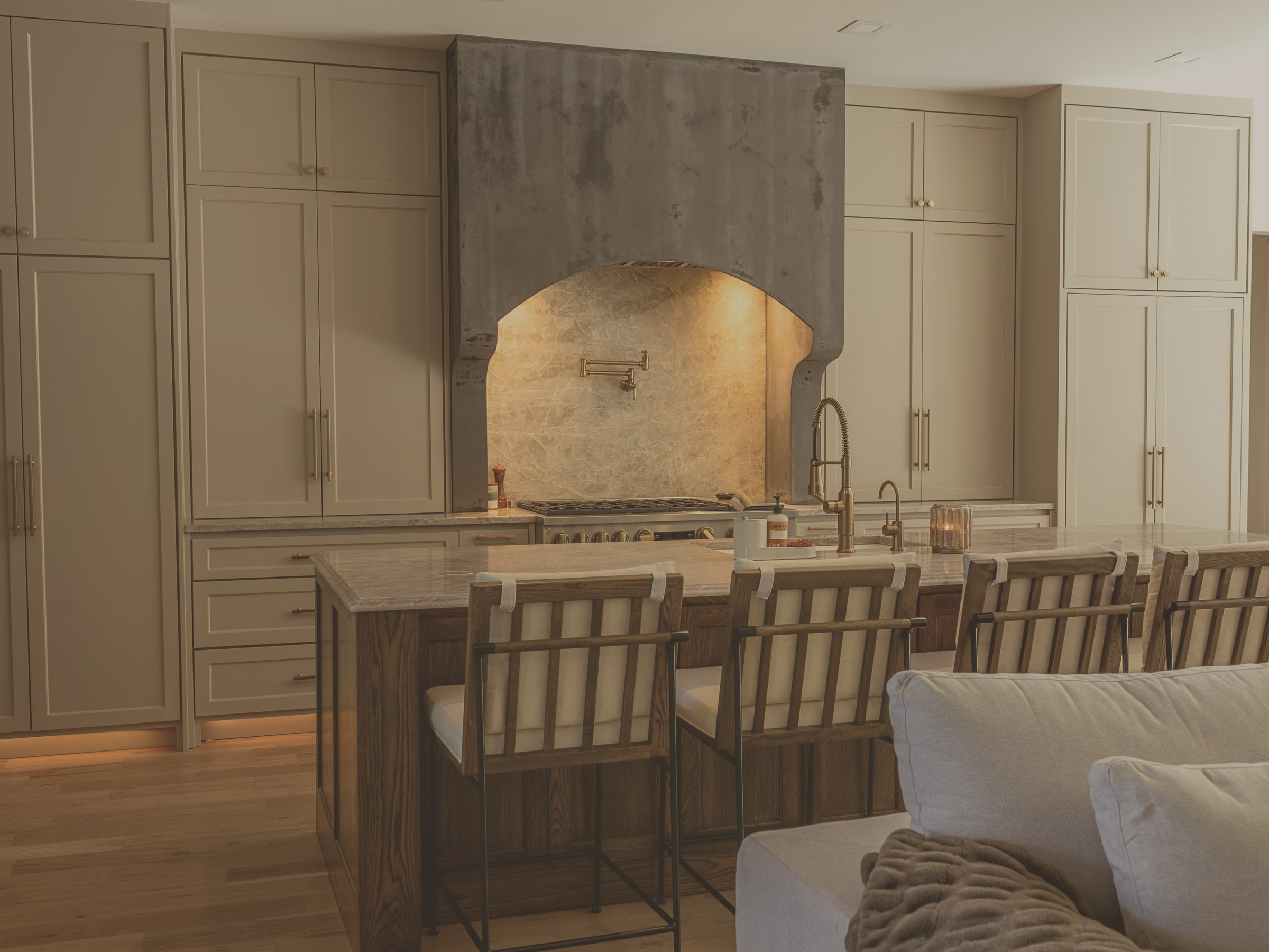 Modern kitchen designed by Interiors DBK in Colleyville, TX with Taj Mahal Quartzite, a large island, and custom hood range.
