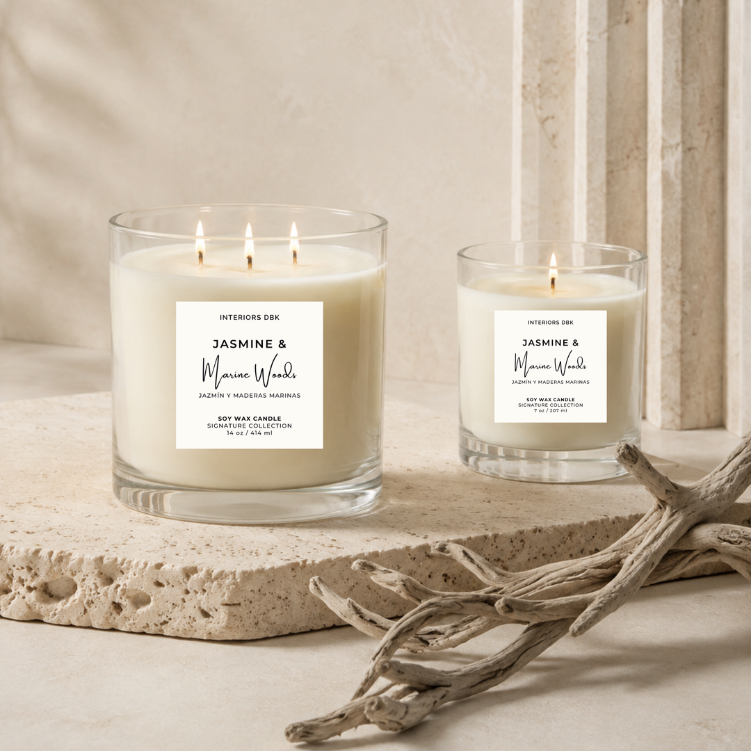 Small and large non-toxic soy candles by Interiors DBK. Jasmine &amp; Marine Woods by Interiors DBK from the Signature Collection. Styled on a stone slab with driftwood in a warm neutral interior setting.
