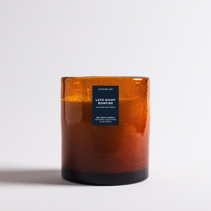 Late Night Bonfire soy wax candle designed in an amber glass jar candle by Interiors DBK photographed on a clean white background.