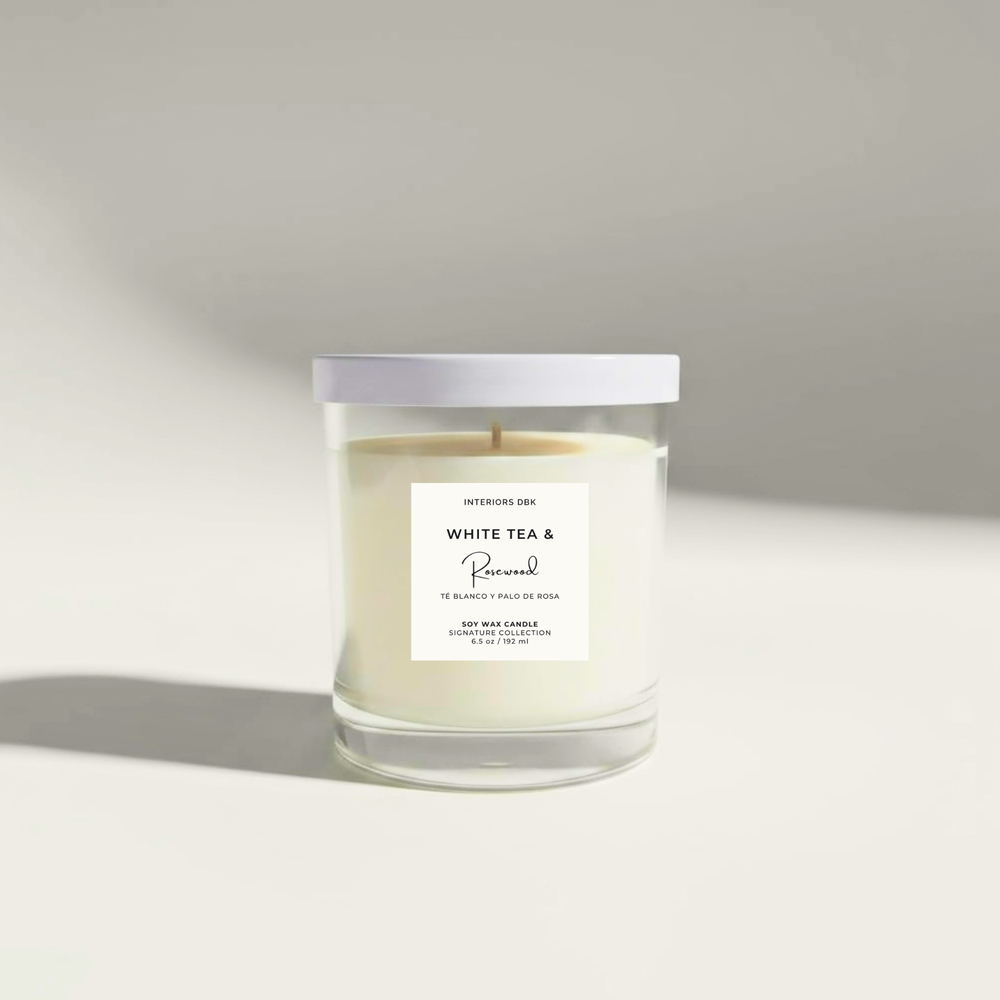 White Tea & Rosewood 6.5 oz soy candle by Interiors DBK in clear glass vessel with white metal lid